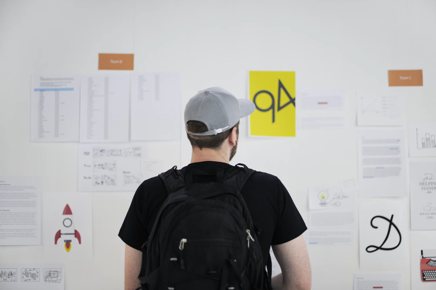 A product manager looking over project details that are mapped out on a whiteboard.
